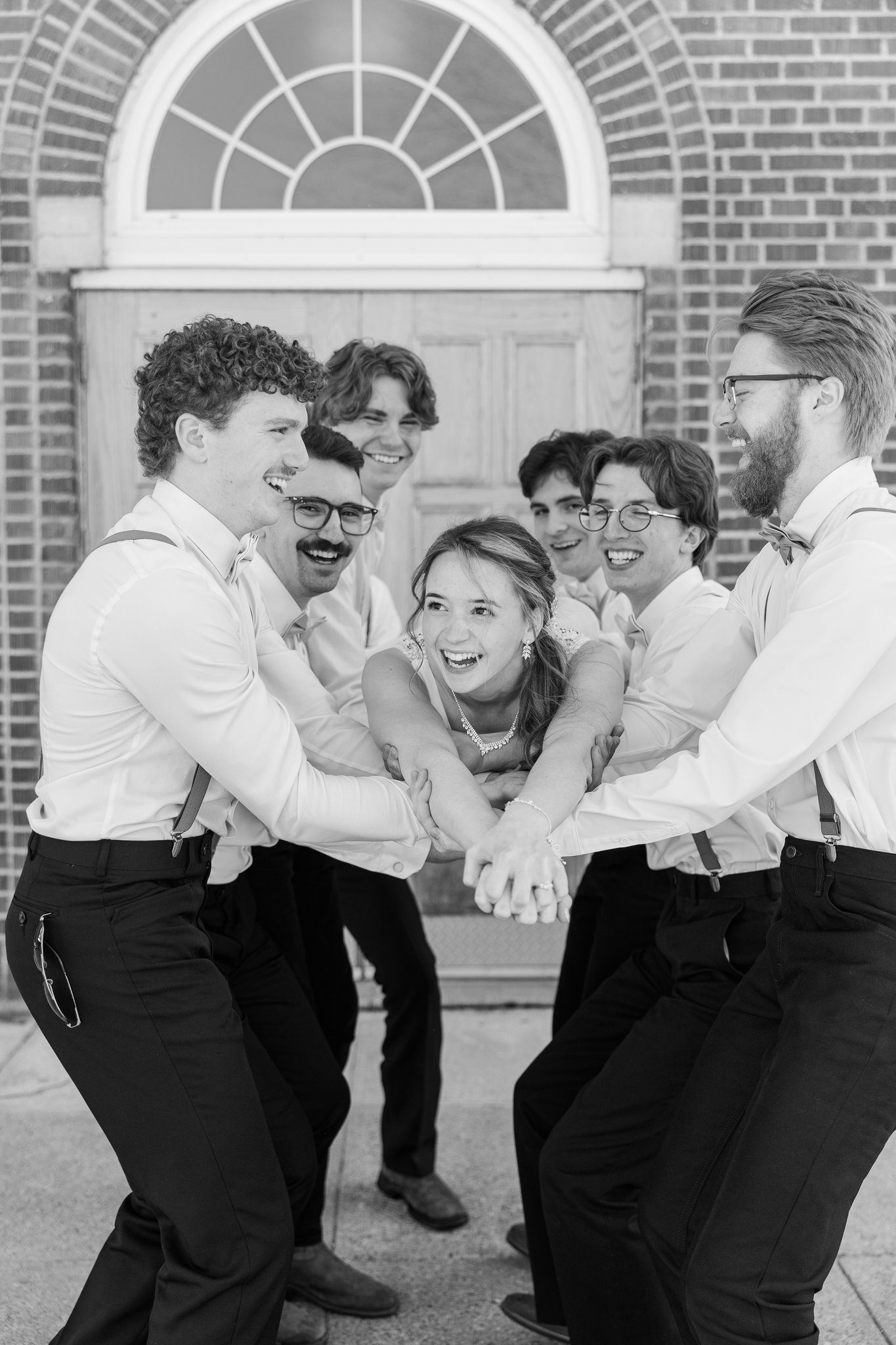 Groomsman portrait in orange suspenders and bow tie