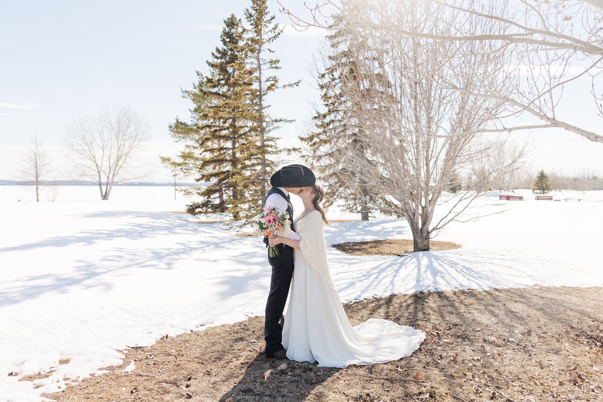 Bride and groom walking together through the snow holding hands