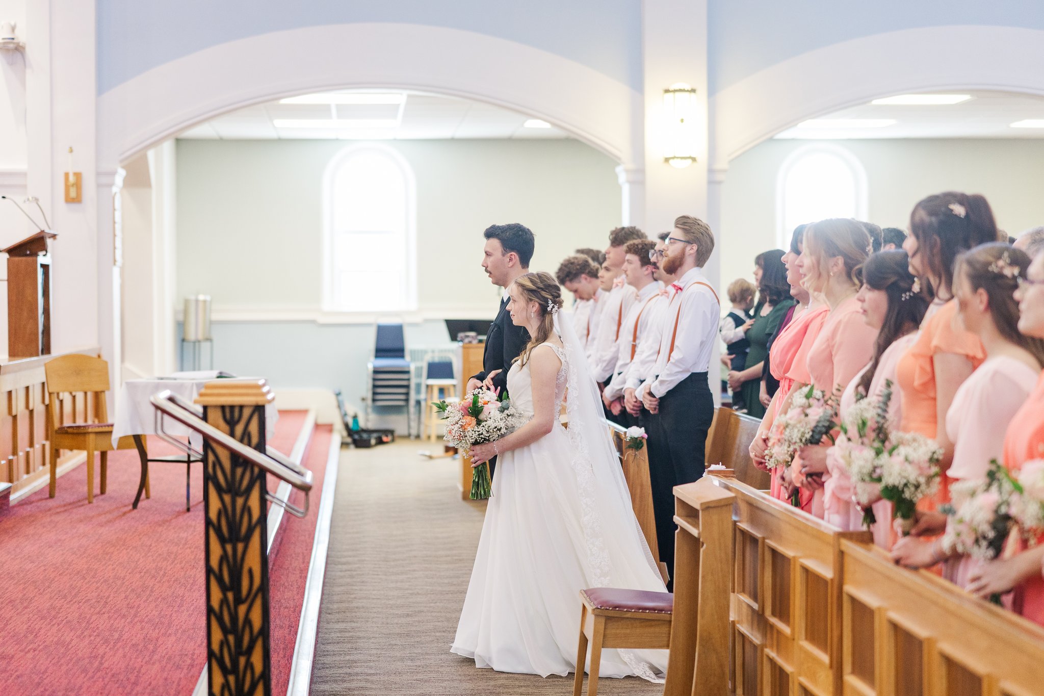 Wide view of church during ceremony with stained glass windows